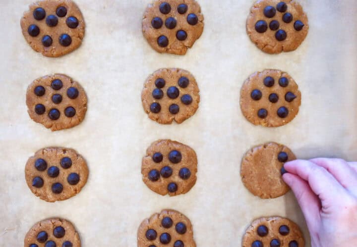 Topping the cookies with chocolate chips.
