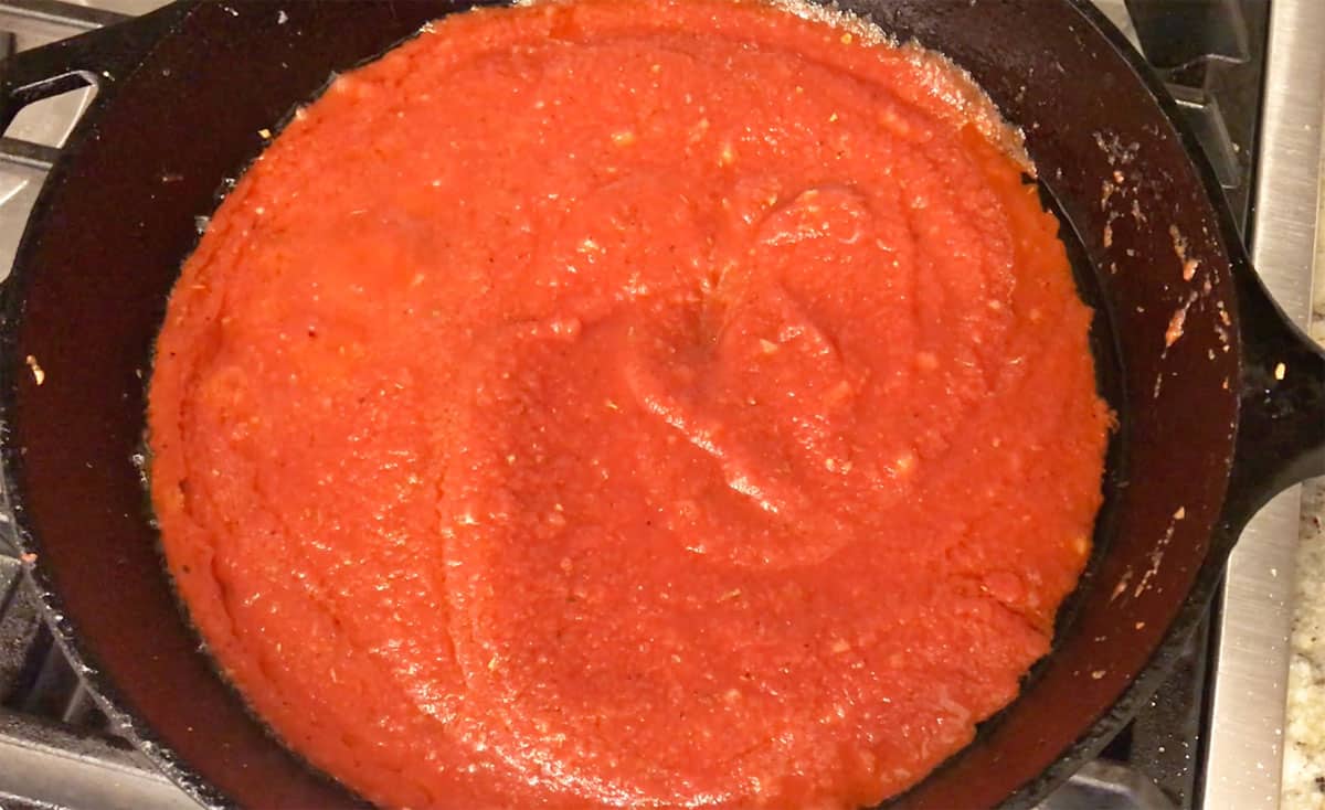 Adding tomato sauce.