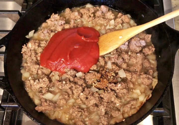 Adding ketchup to the skillet.