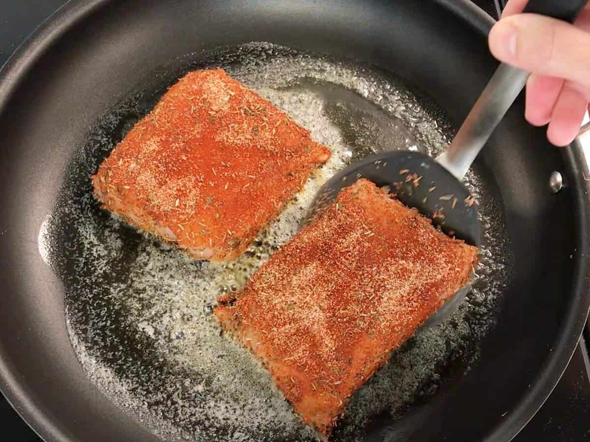 Cooking the fish on the first side.