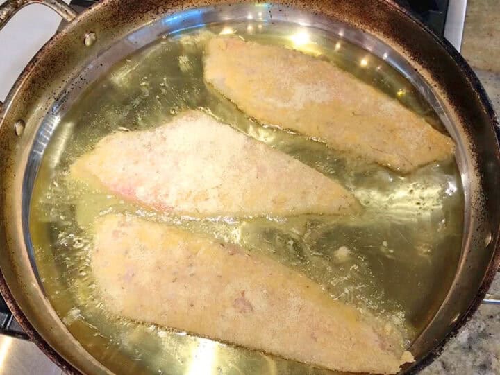 Cooking the fish in oil.