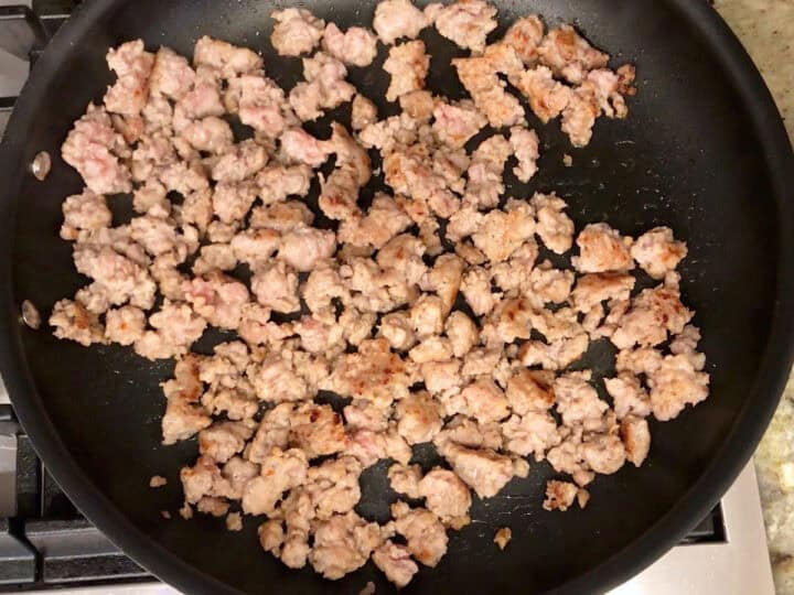 Cooking sausage in a skillet.