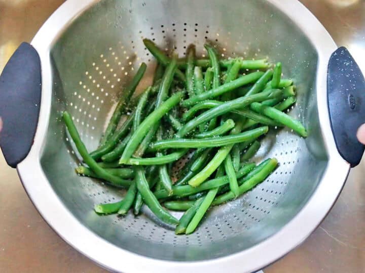 Draining the green beans in a colander.