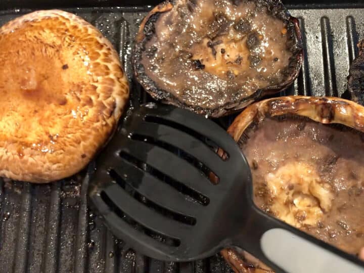 Flipping the mushrooms on the grill.