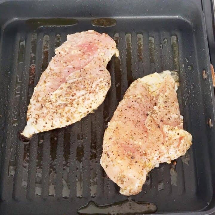 Grilling the chicken on the first side.