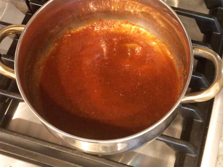 Heating the sauce on the stovetop.