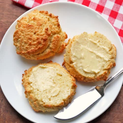 Keto biscuits are spread with butter.