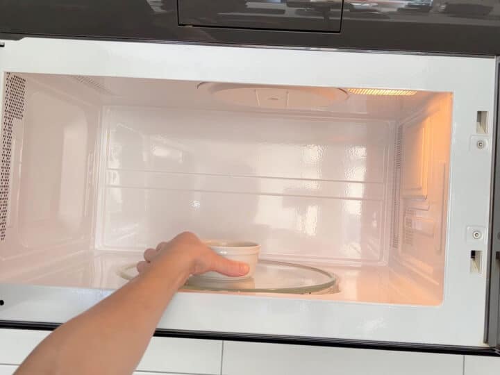 Placing the cake in the microwave.