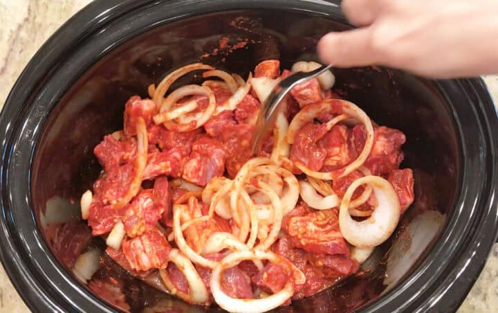 Mixing the ingredients in the slow cooker bowl.