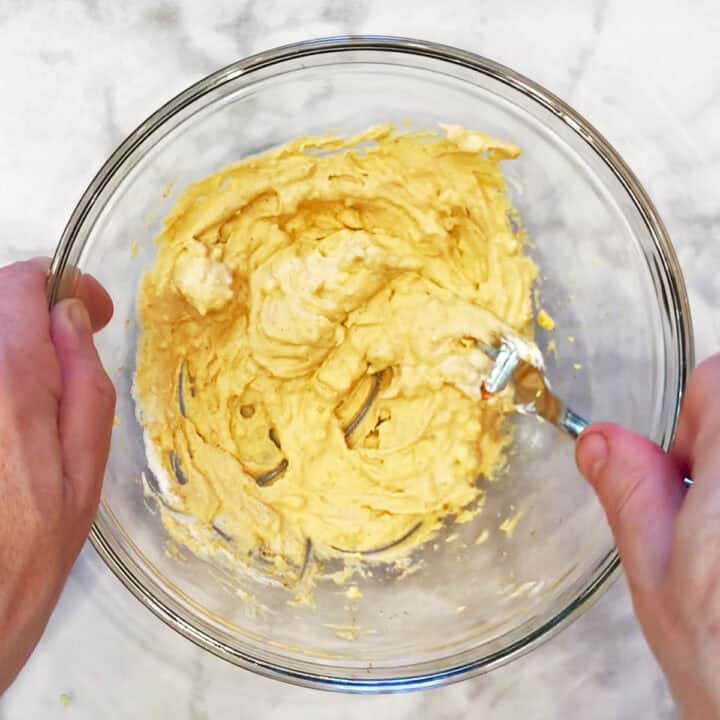 Mixing the egg yolks with sour cream, mustard, and spices.