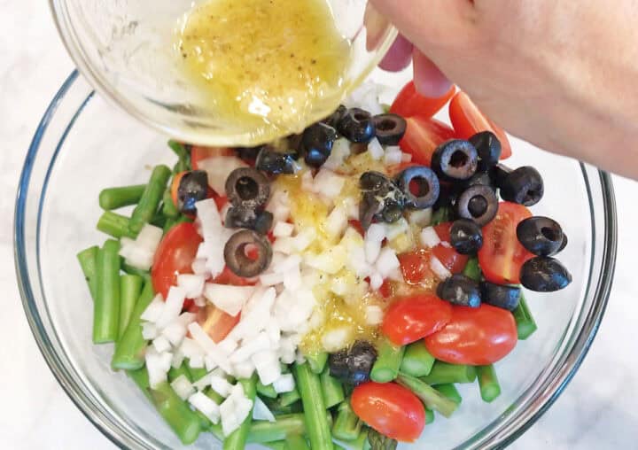Pouring the dressing on top of the salad.