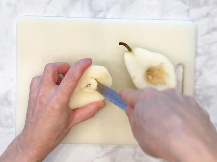 Prepping the pears by removing their core.