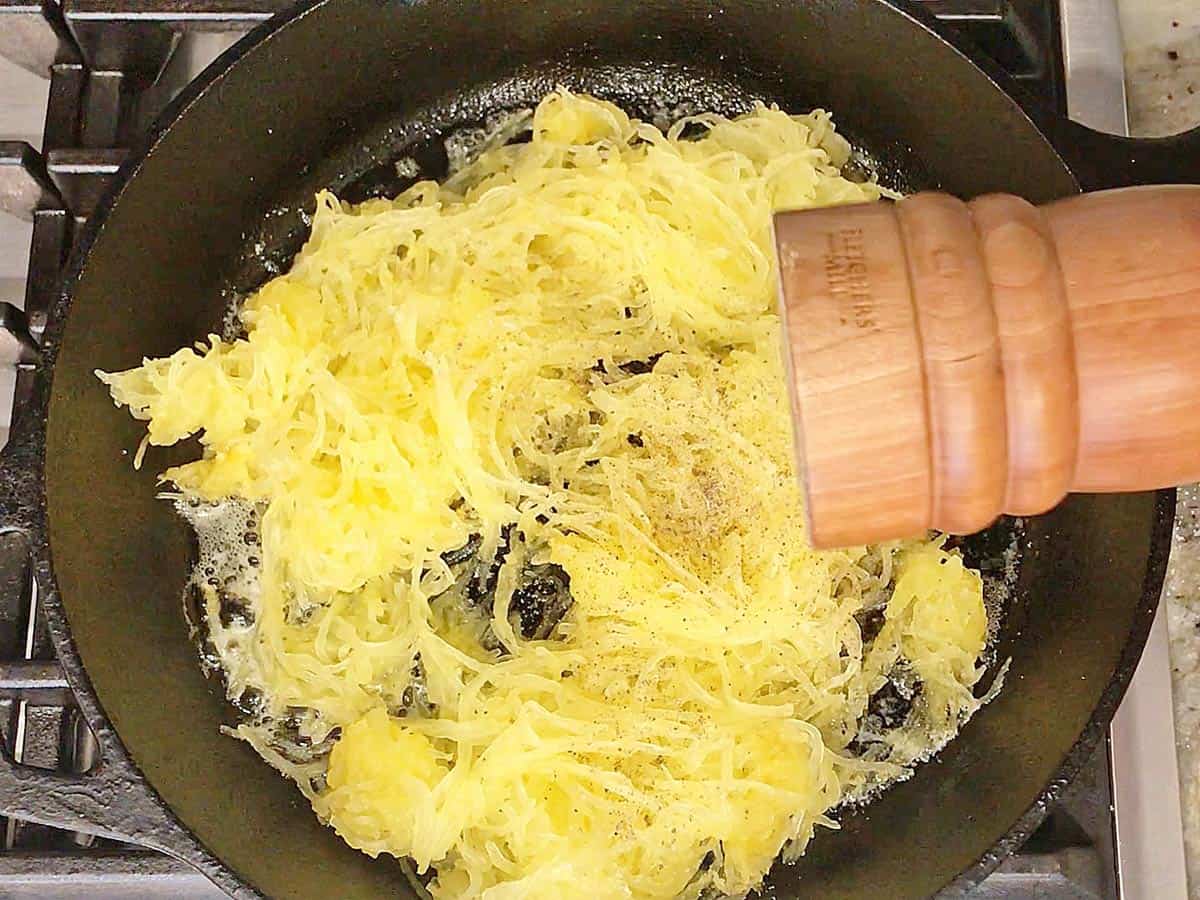 Seasoning the squash strands with black pepper.