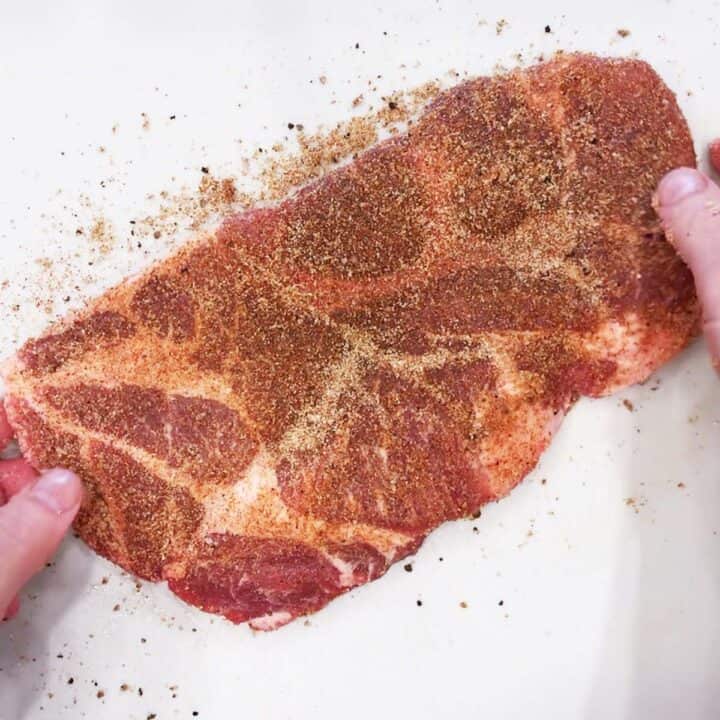 Seasoning the steak.