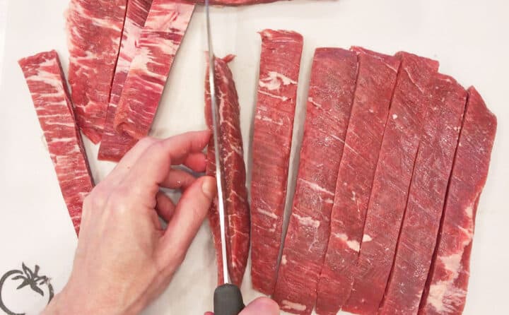 Slicing the beef strips lengthwise.