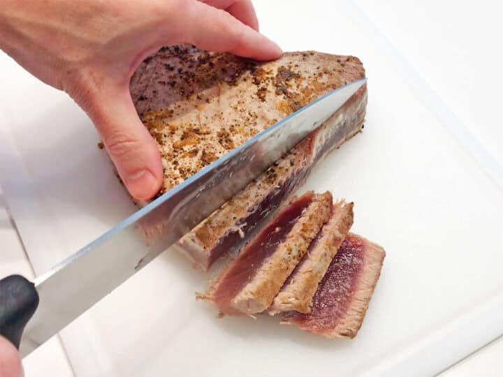 Slicing the tuna on a cutting board.