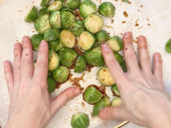 Coating the sprouts in the marinade.