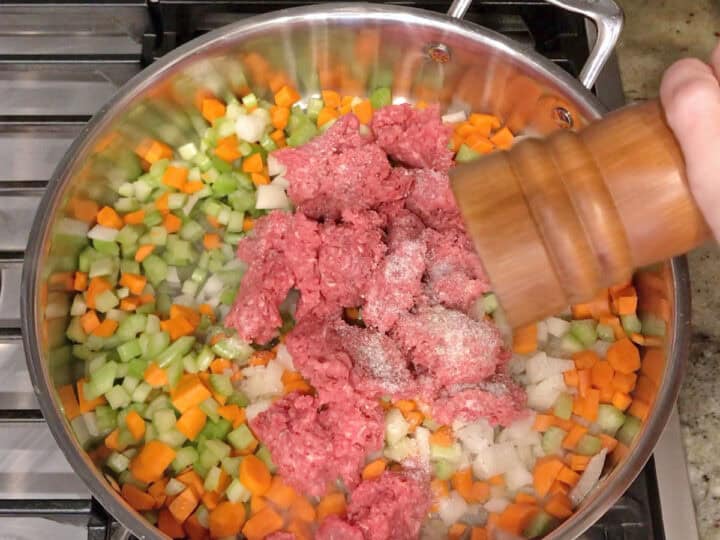 Seasoning the vegetables and beef with black pepper.