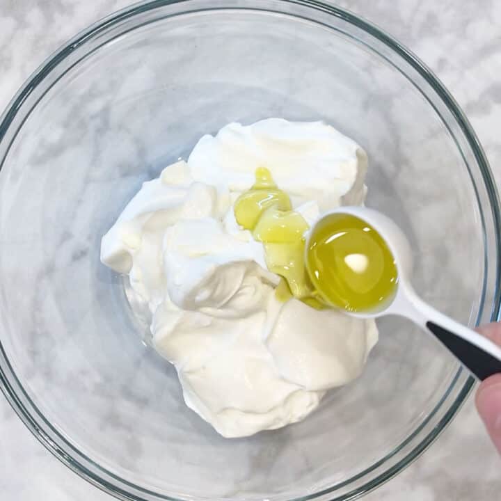 Adding olive oil to the yogurt.