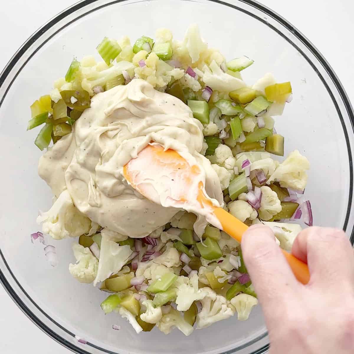 Adding the dressing to the salad.