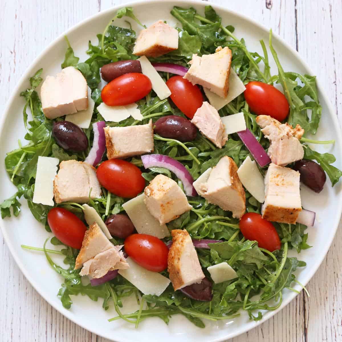 Cubed chicken was added to arugula salad.