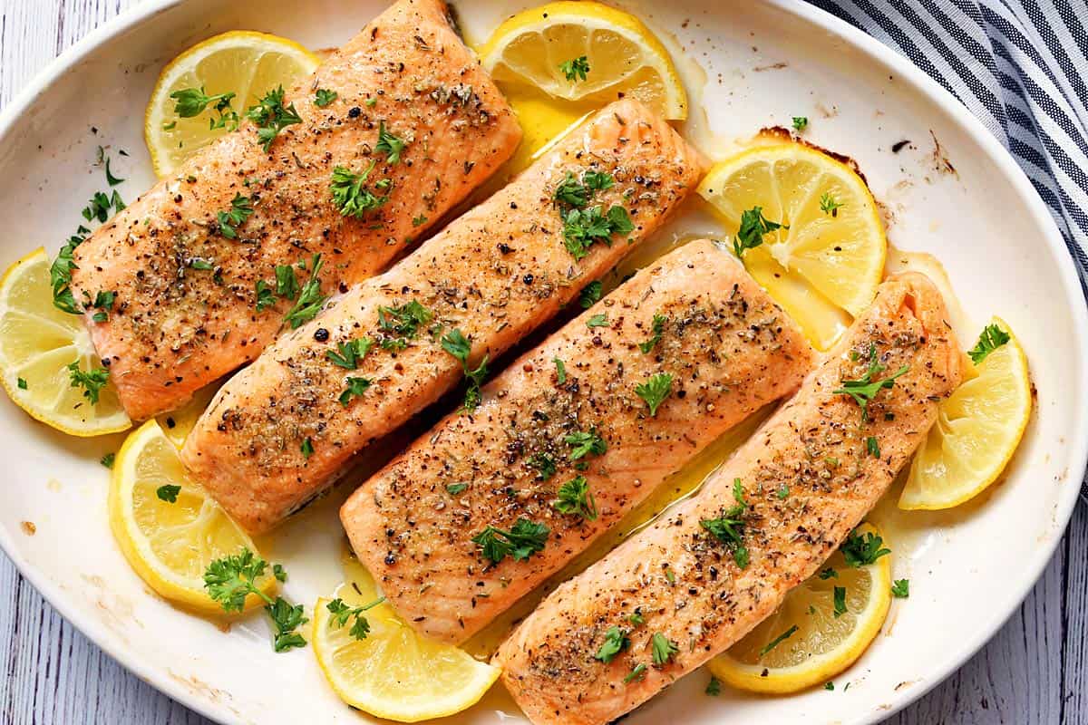 Baked salmon is served with lemons.