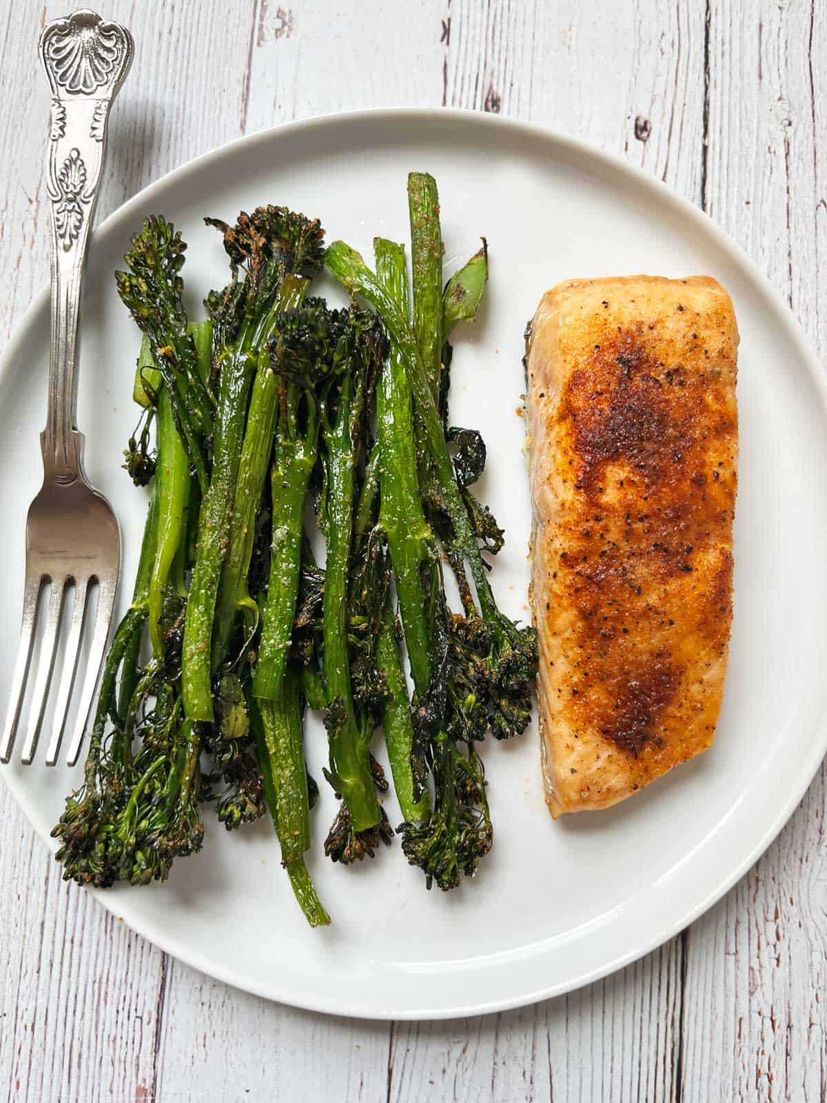 Baked salmon seasoned with chili powder is served with roasted broccolini.