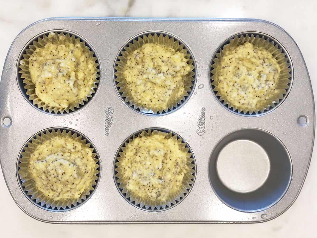 The batter was divided between the muffin cups.