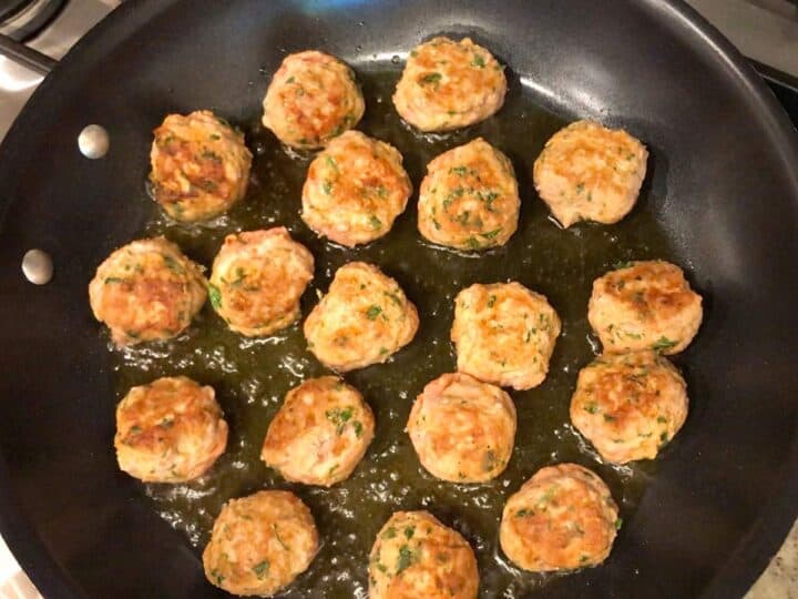 Browning the meatballs in a skillet.