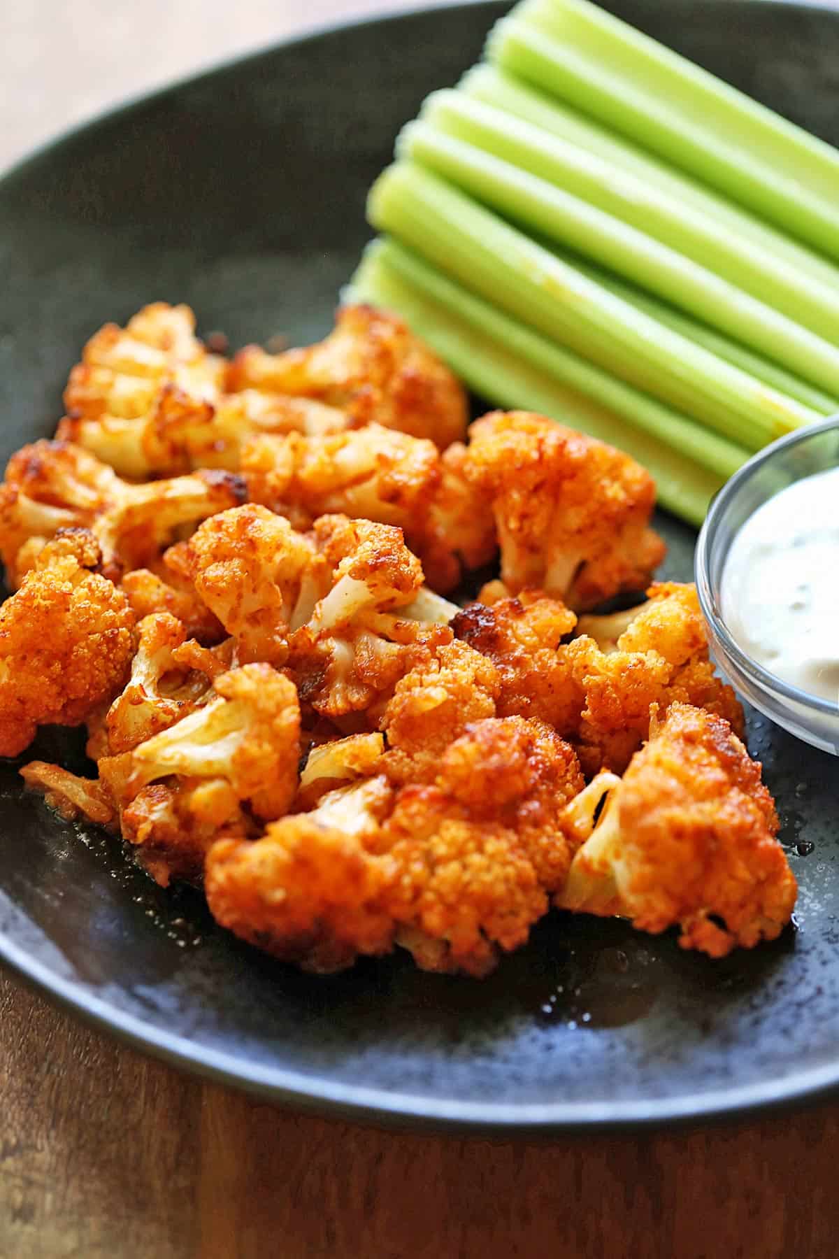 Buffalo cauliflower is served with celery and blue cheese dressing.