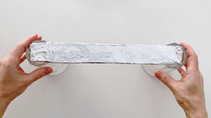 Suspending a foil-covered ruler between two cups.