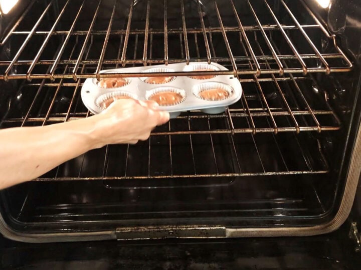 Placing the cupcakes in the oven.