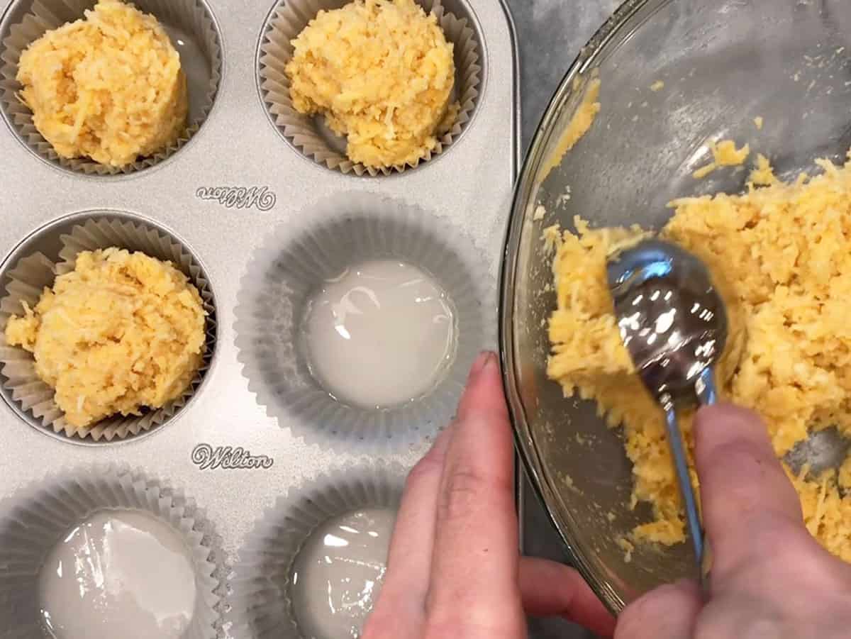 Dividing the batter between the muffin cups.