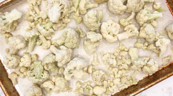 Frozen cauliflower florets on a baking sheet.