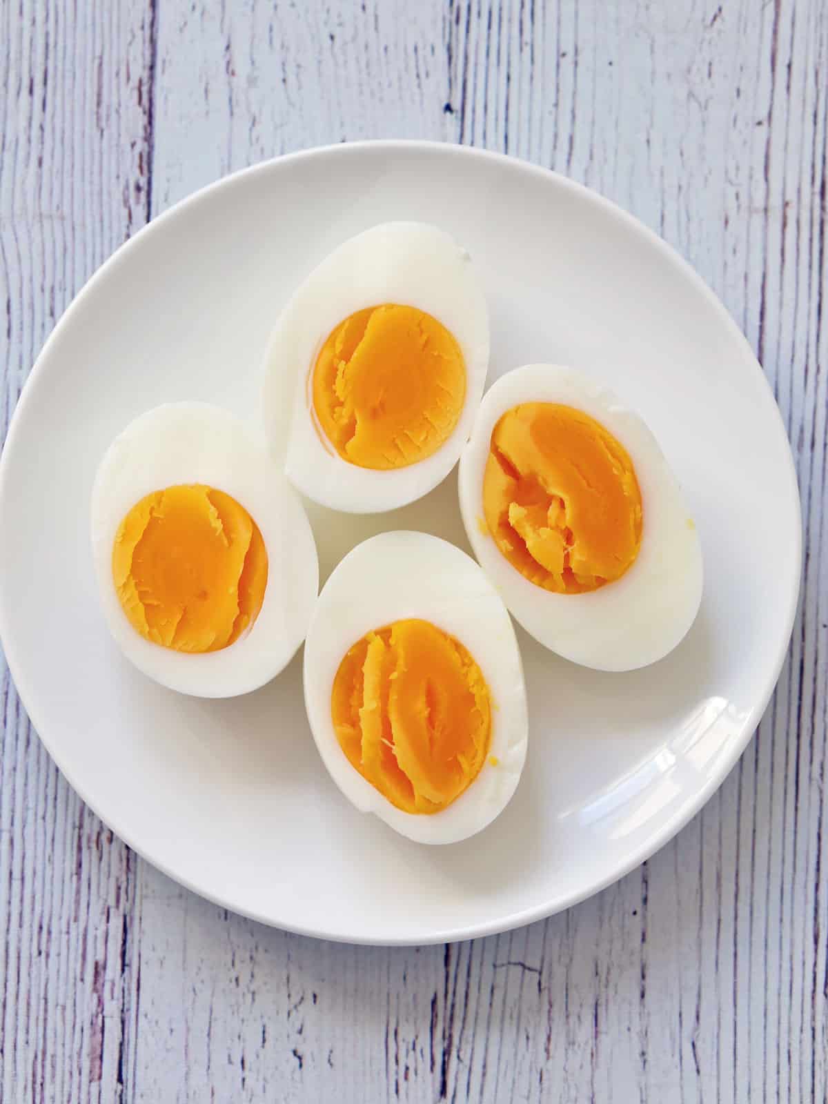 Hard-boiled eggs on a white plate.