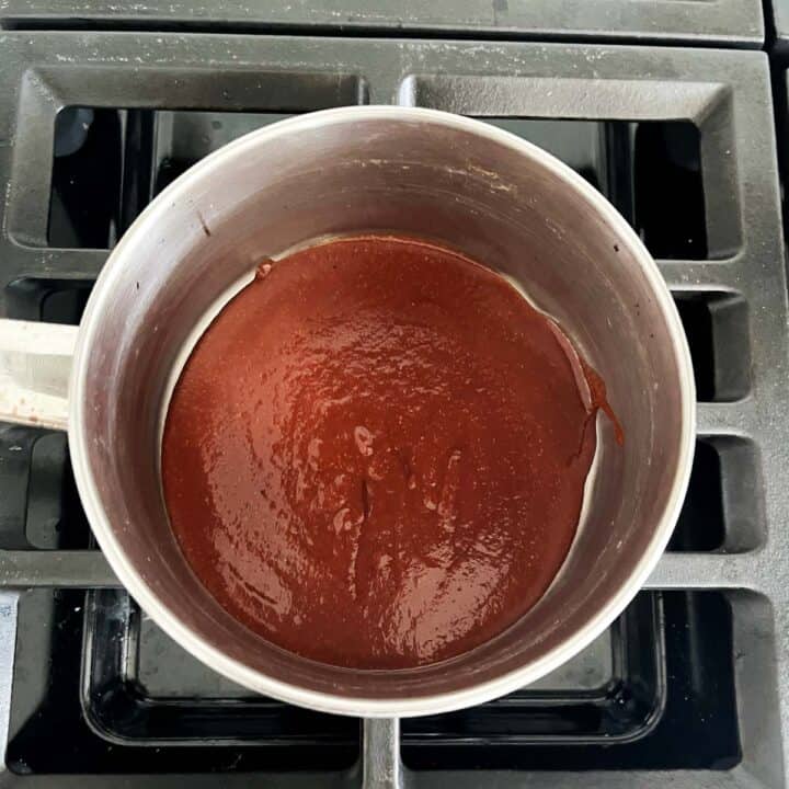 Heating the sauce on the stovetop.