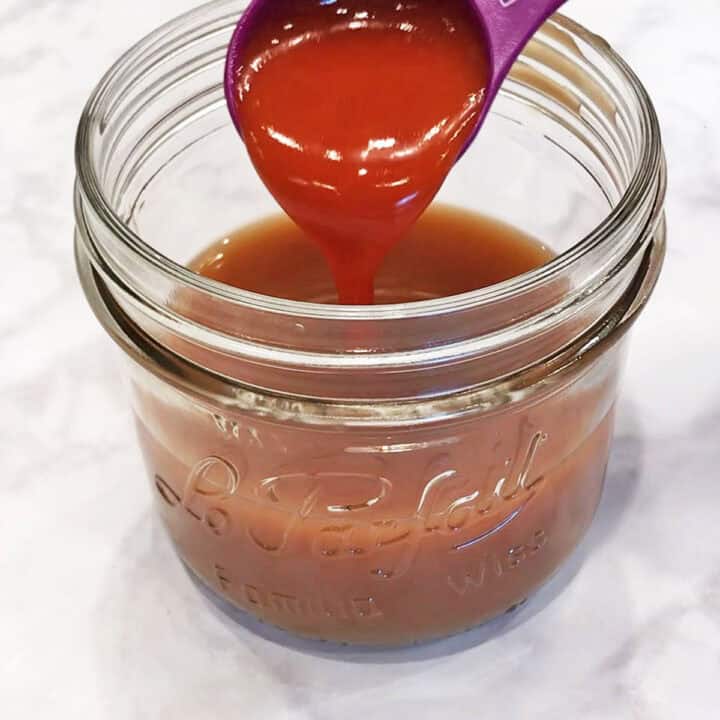 Adding the sauce ingredients to a glass jar.