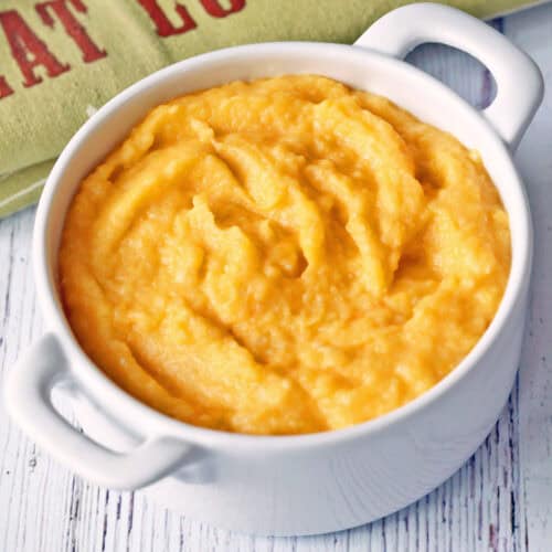 Mashed butternut squash is served in a white bowl.