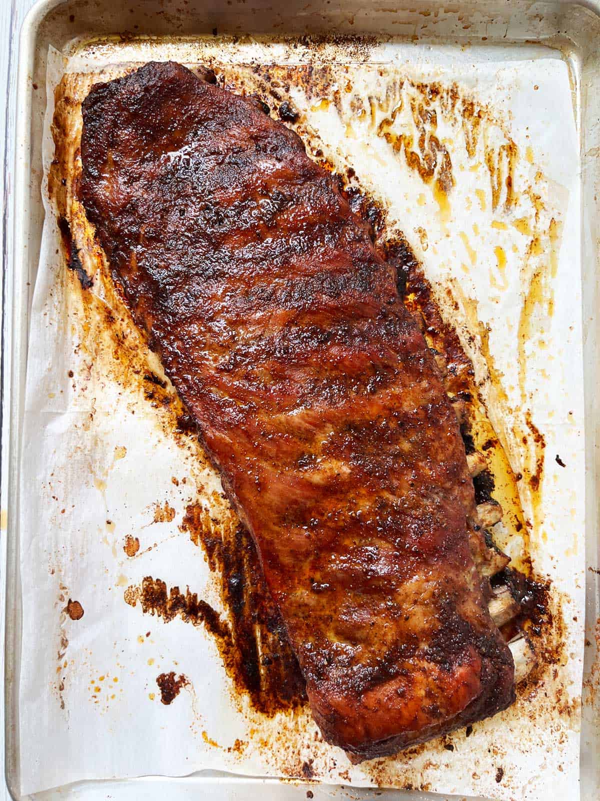 A slab of spare ribs on a baking sheet.