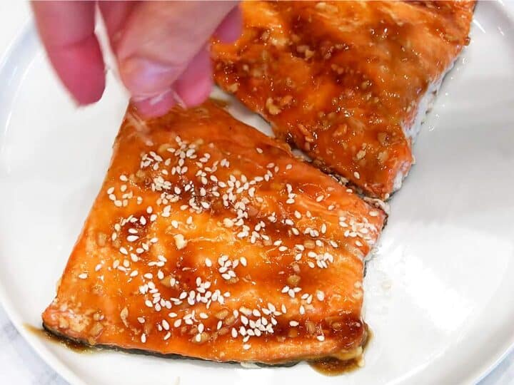 Sprinkling the fish with sesame seeds.