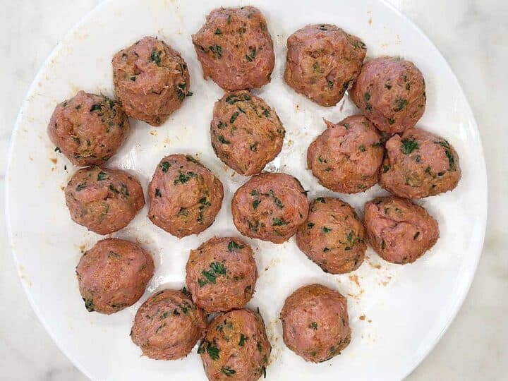 Shaped meatballs on a white plate.