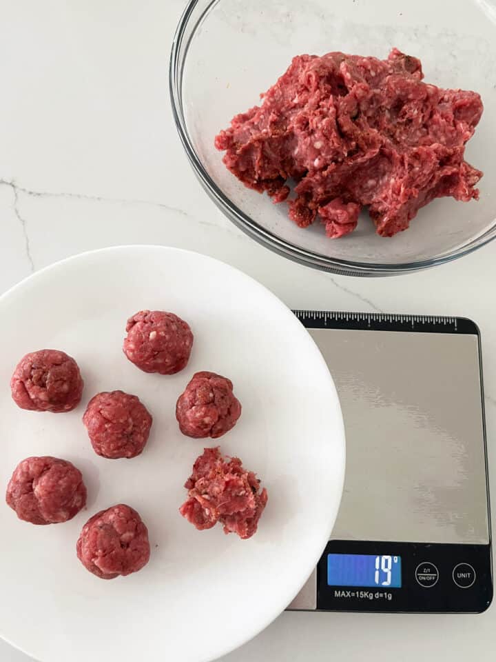 Shaping the meatballs and weighing them for accuracy.
