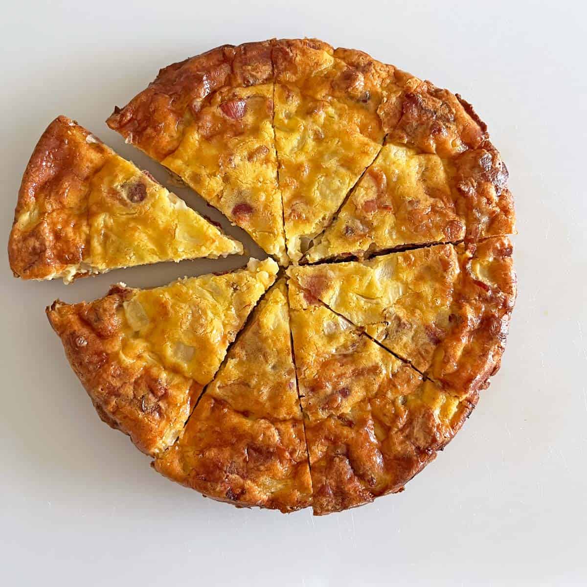 The quiche was sliced on a cutting board.