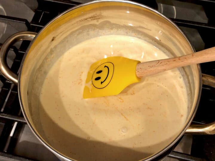 Thickening the cheese sauce on the stovetop.