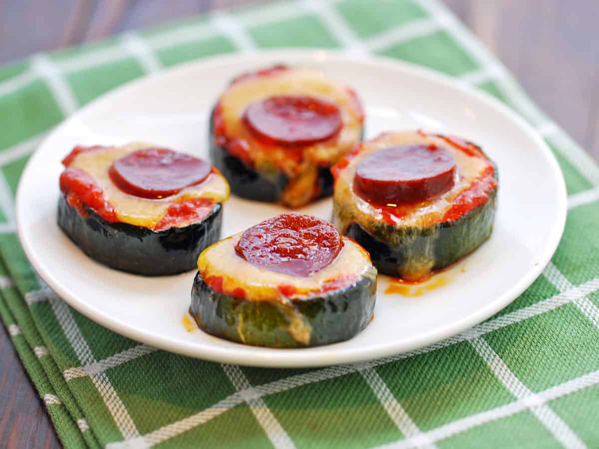 Zucchini pizza bites are topped with cheddar and chorizo.