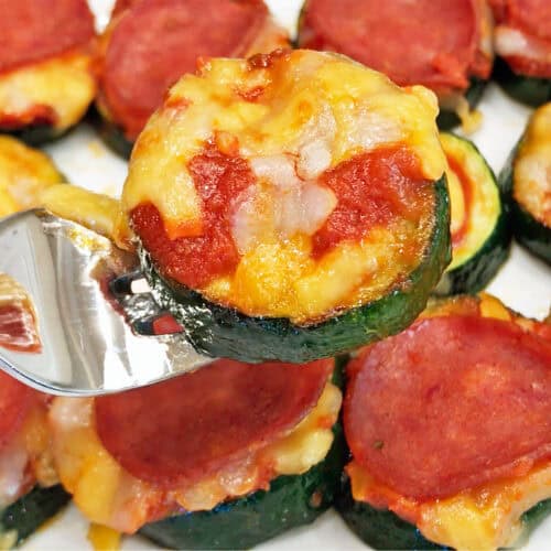 Zucchini pizza bites are served with a fork.
