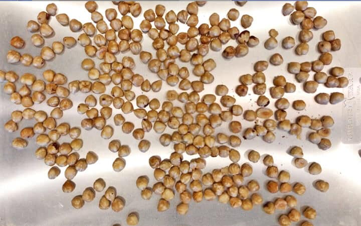 Toasting the hazelnuts on a baking sheet.