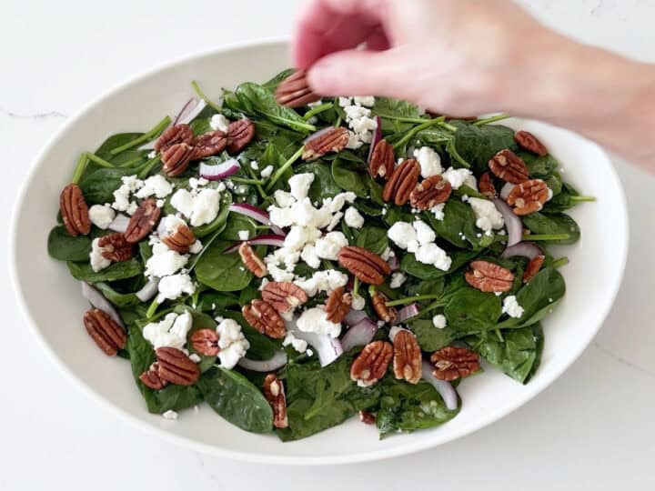 Adding pecans to the salad.