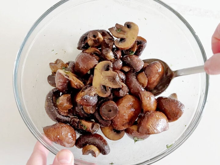 Tossing the mushrooms in melted butter.