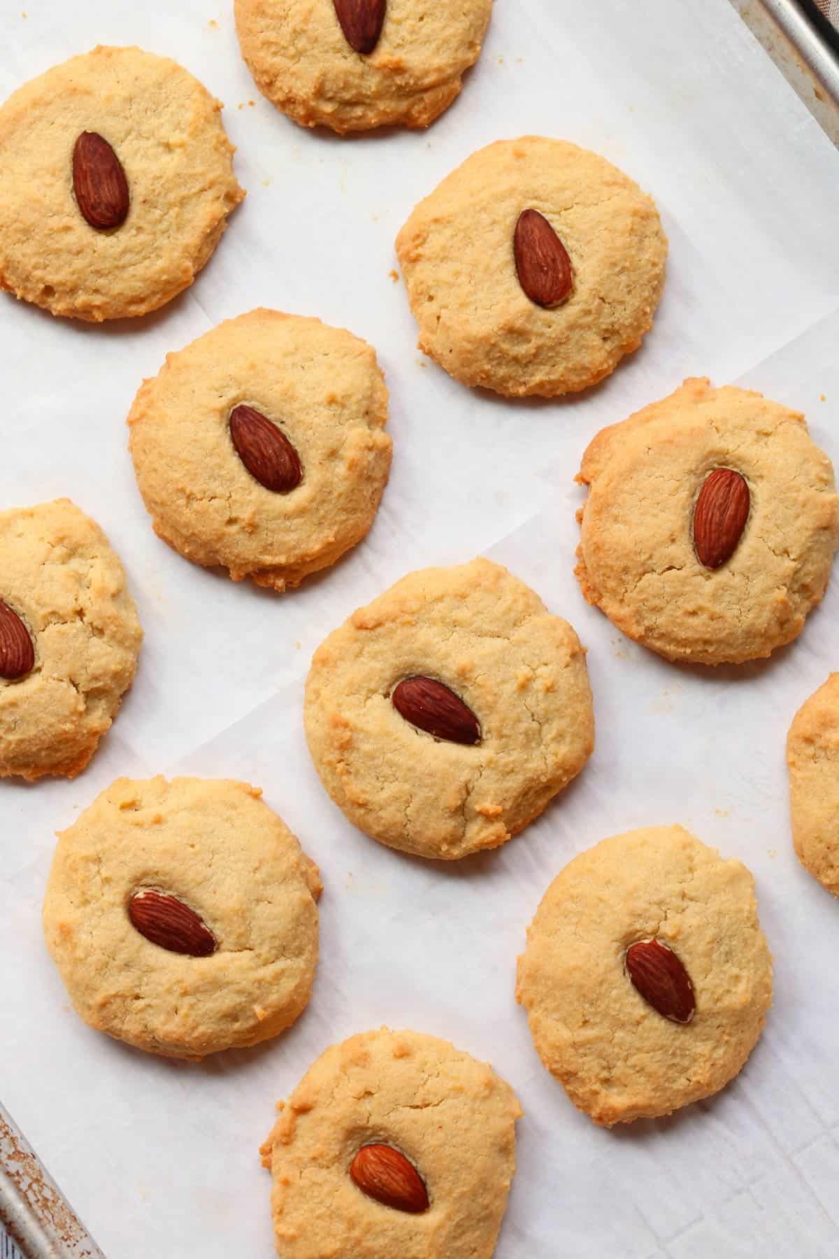 Almond flour cookies are served on a parchment-lined baking sheet.